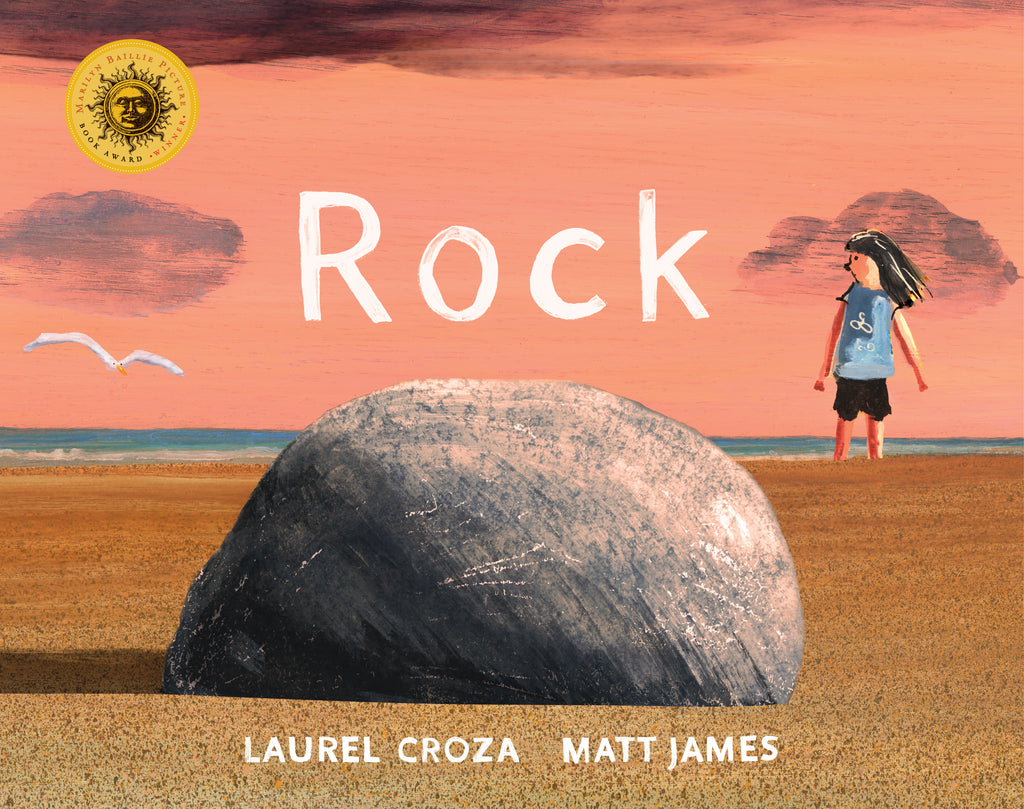  Cover: Rock. Written by Laurel Croza and illustrated by Matt James. The illustrations were created with acrylic paint. A round gray rock sits in the foreground on a sandy beach. The perspective of the illustration makes the rock look large. In the background a young child with  light skin tone stands in the sand. A white seagull is flying in the distance. The blue water can be seen on the horizon. The rock is casting a shadow to the left and the sky is a peachy orange. 
