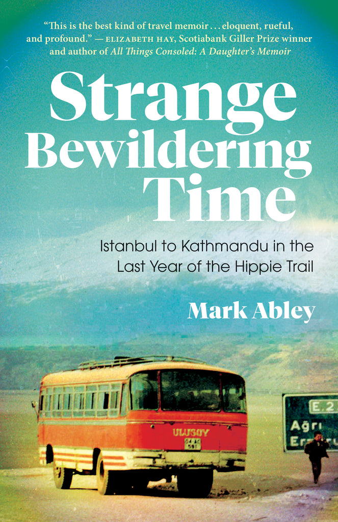  Cover: Strange Bewildering Time: Istanbl to Kathmandu in the Last Year of the Hippie Trail by Mark Abley. A vintage colour photograph of a red-orange 1960s bus on a deserted road. Beside the bus is one half of a road sign, with a dark-skinned man standing in front of it. In the background are rolling green hills and a white-tipped mountain, with a blue-green sky above. 
