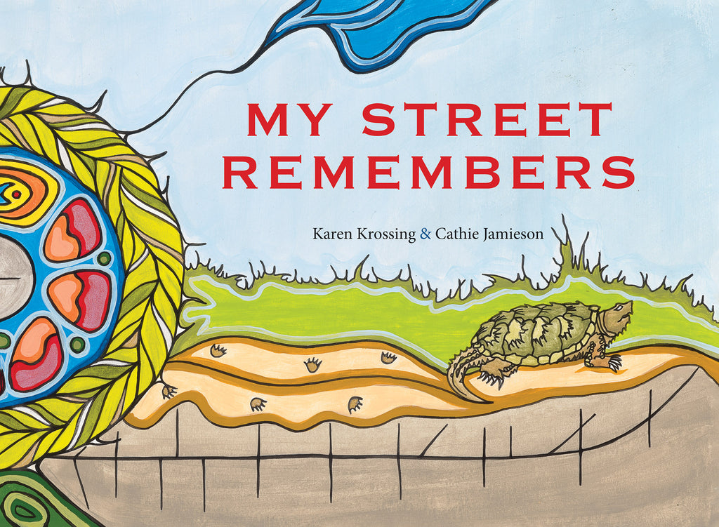  Cover: My Street Remembers. Written by Karen Krossing and illustrated by Cathie Jamieson. Paintings were inspired by illustrator’s Anishinaabe and Haudenosaunee background, showing organic shapes in thick outlines. A turtle crawls along the sand, leaving footprints behind. The sky is blue. Grass grows above, and under it there is dark earth with a long, curving black line bisected by shorter vertical lines. Pictured on the left side of the page is half of a medicine wheel ringed with a braided grass ring. 