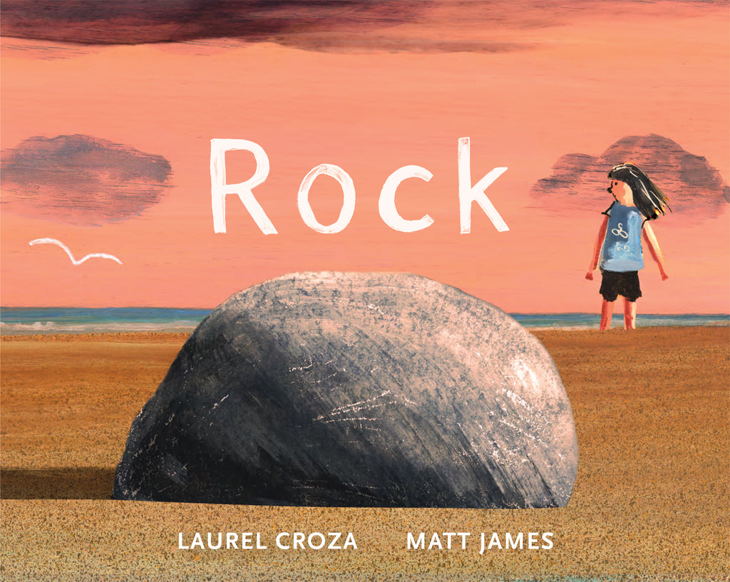  Cover: Rock. Written by Laurel Croza and illustrated by Matt James. The illustrations were created with acrylic paint. A round gray rock sits in the foreground on a sandy beach. The perspective of the illustration makes the rock look large. In the background a young child with  light skin tone stands in the sand. A white seagull is flying in the distance. The blue water can be seen on the horizon. The rock is casting a shadow to the left and the sky is a peachy orange. 