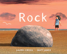  Cover: Rock. Written by Laurel Croza and illustrated by Matt James. The illustrations were created with acrylic paint. A round gray rock sits in the foreground on a sandy beach. The perspective of the illustration makes the rock look large. In the background a young child with  light skin tone stands in the sand. A white seagull is flying in the distance. The blue water can be seen on the horizon. The rock is casting a shadow to the left and the sky is a peachy orange. 