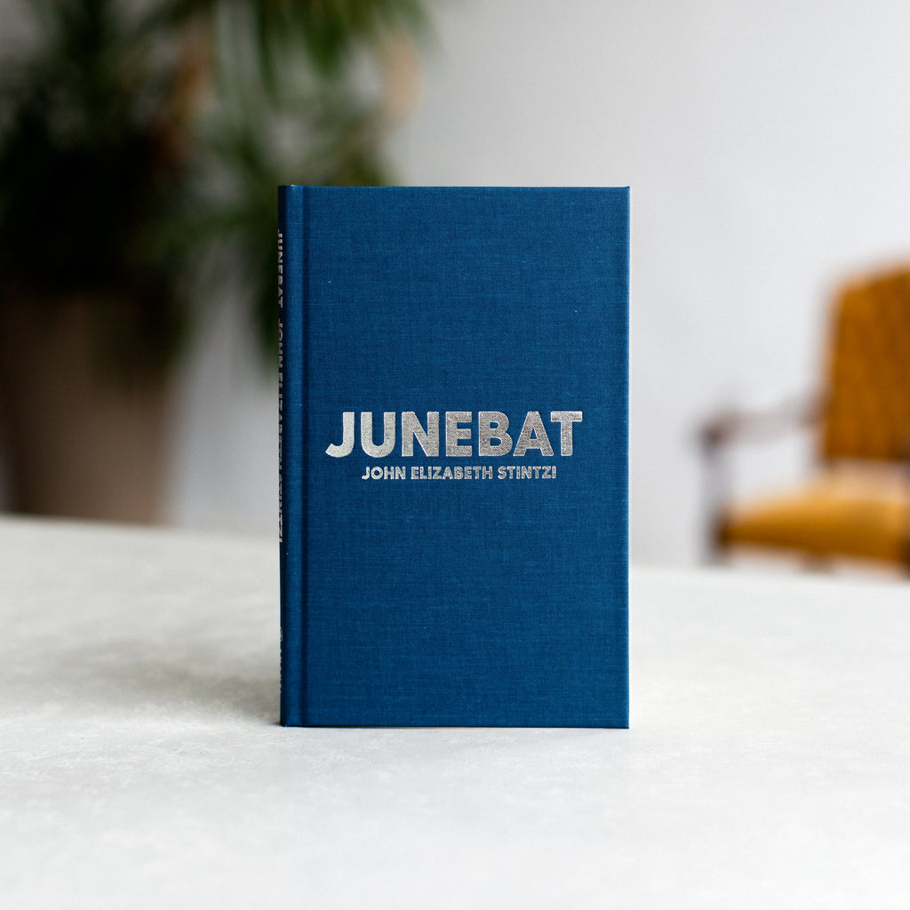  Dark blue background. Text: Junebat. John Elizabeth Stintzi. 