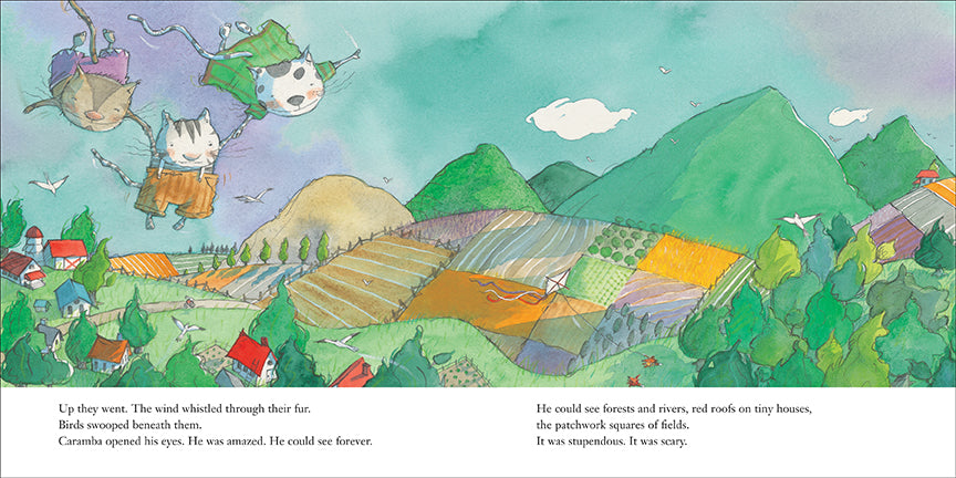  Green hills, trees, fields, and houses are seen from the sky. Two cats are flying and carrying a cat in between them by holding hands. Text: Up they went. The wind whistled through their fur. Birds swopped beneath them. Caramba opened his eyes. He was amazed. He could see forever. He could see forests and rivers, red roofs on tiny houses, the patchwork squares of fields. It was stupendous. It was scary. 