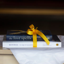  A photo of copies of Minimal: For Simple and Sustainable Living and The Lost Spells wrapped together with a yellow ribbon. 