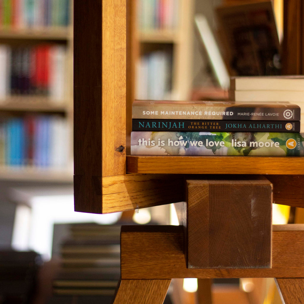  A photo of copies of This Is How We Love, Narinjah, and Some Maintenance Required in the Anansi book shop. They are laid down on top of a stool in a sunbeam. 